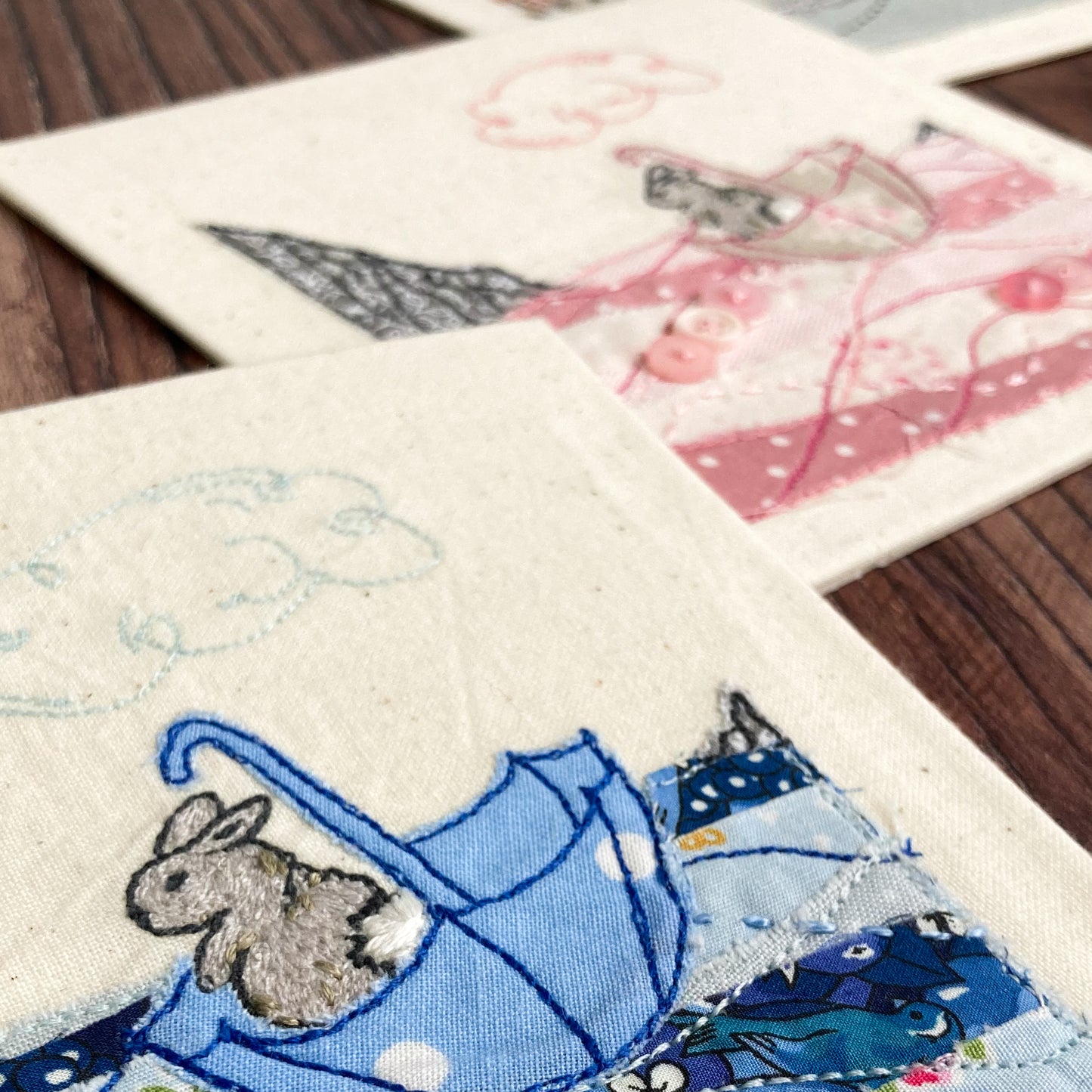 Blue umbrella and sea applique with embroidered beige bunny, pink sea and umbrella applique with embroidery and embroidered bunny in the background 