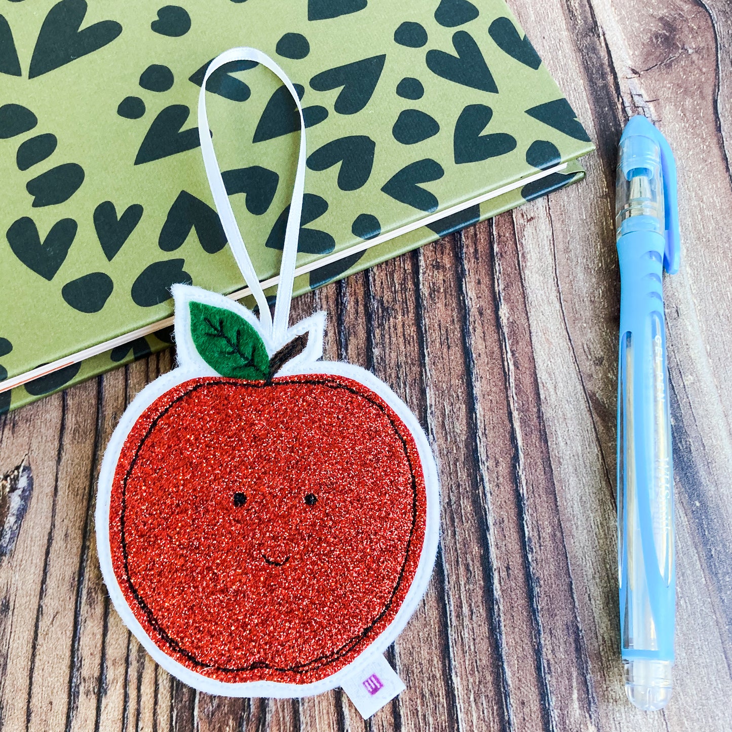 Red Glittery Apple Decoration with a notebook and pen