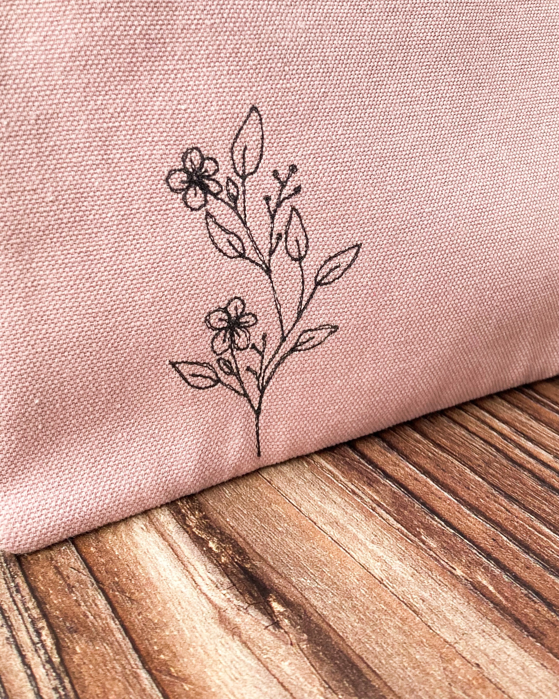 Pink fabric with a black embroidery of Wild flowers in black thread